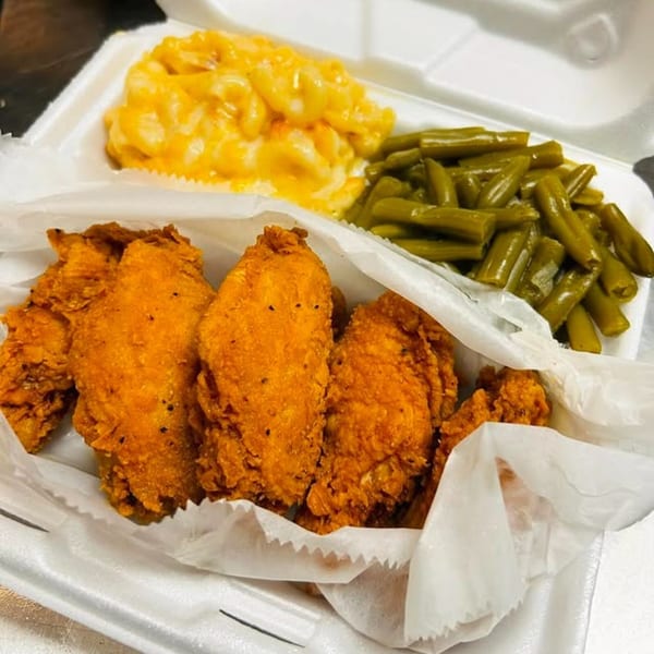 A takeout container with crispy fried chicken, creamy macaroni and cheese, and green beans.